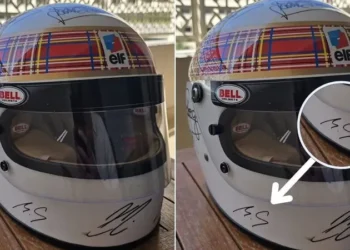 Com ajuda da esposa, Schumacher assina capacete em rara rara aparição em tributo da F-1